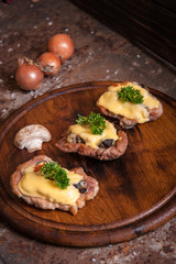 Meat patties with mushrooms and cheese, decorated with greenery