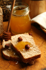 Fresh bread with honey on wooden background