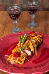 Grilled meat with sweet sauce on the background of two glasses of wine