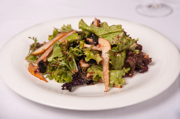 Salad with meat and lettuce on a plate in a restaurant