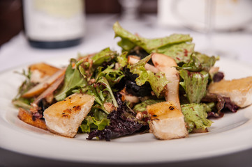 Salad with meat and lettuce on a plate in a restaurant