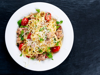Italian Tuna Pasta spaghetti with tomato, chilli, parmesan and wild rocket  lives. on old blue stone table