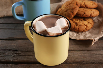 Tasty cocoa and marshmallow in old-fashioned metal mug on the table