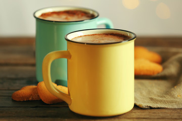 Tasty cocoa in metal old-fashioned mugs on the table