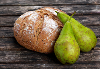 Fresh Home made Bread and Pears on old wooden table.