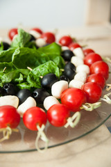 Cherry tomatoes with cheese, olives and basil on a skewer