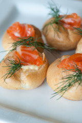 Red fish in a small buns with greens