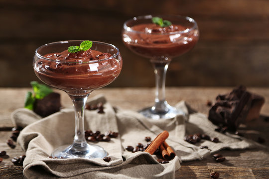 Chocolate dessert in glasses on wooden background