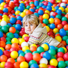 Fototapeta na wymiar child playing at colorful plastic balls playground 