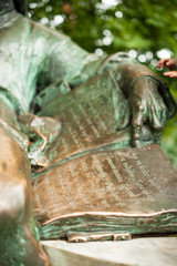 Metal monument, where the man is holding a book in his hands