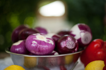 Onions in a tin bowl with red pepper and lemon
