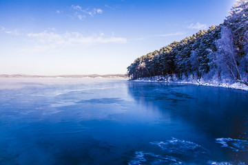 Winter Russian lake - water, mist, snow forest and mountains