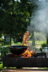 Cast-iron cauldron stands on the gridiron, and under it is a fire