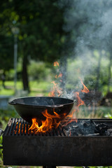 Cast-iron cauldron stands on the gridiron, and under it is a fire