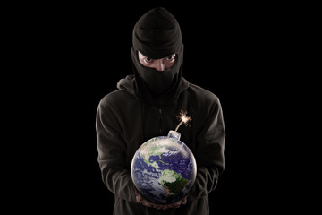 Portrait of man holding bomb with globe against black background