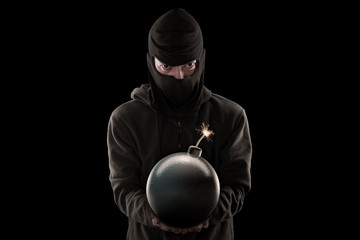 Portrait of man holding bomb against black background