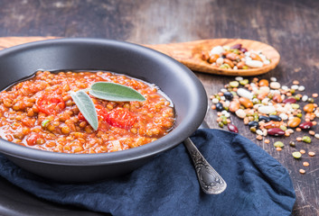 Lentils stew in bowl with tomatoes.