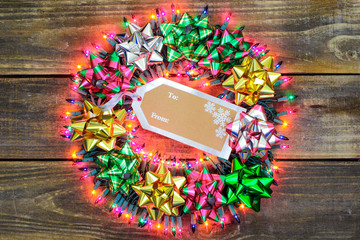 Christmas wreath with bows and holiday lights hanging on door