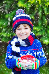 Little kid boy holding big cup with chocolate drink in winter