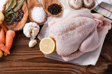 Whole raw chicken with vegetables and pepper