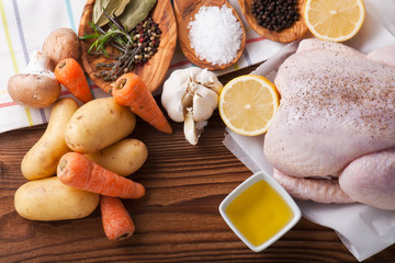 Whole raw chicken with vegetables and pepper