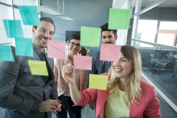 Smiling partners looking at sticky notes.