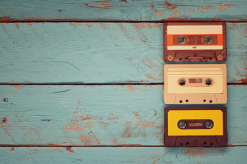 Cassette tapes over blue textured wooden table . top view. retro filter
