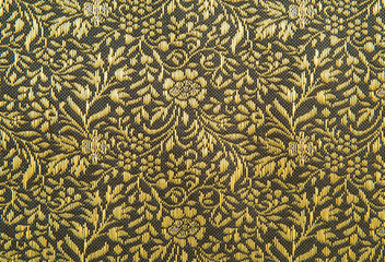 Closeup of yellow fabric pattern with textured  floral ornament.
