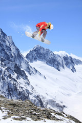 Naklejka na ściany i meble Flying snowboarder on mountains. Extreme sport