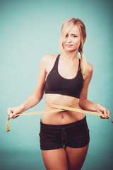 Fitness girl measuring her waistline