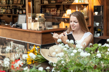 smiling girl sitting at summer terrace and reading book