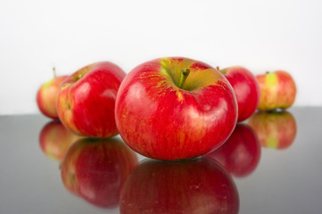 Fototapeta na wymiar A red apples on a black reflective background.