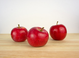 three apples on a wooden background