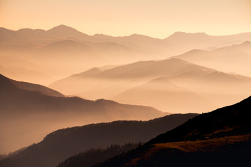 Landscape view of misty mountain hills at sunset