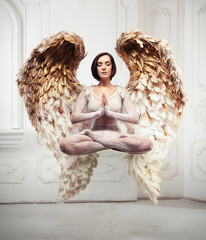 Young woman yoga levitation and meditation concept. Objects flying in room with gold wings.