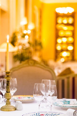Table served with plates, glasses and candles in the restaurant