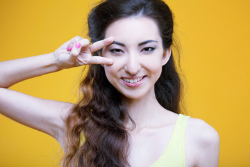 Fashion asian young  girl. Portrait on yellow background. 