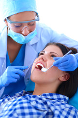 Woman dentist working at her patients teeth