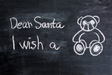 Dear Santa is written on a blackboard and christmas decoration