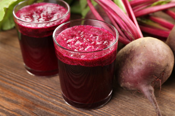 Glasses of beet juice with vegetables on table close up