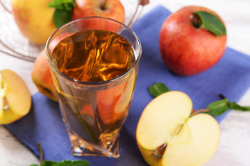 Glass of apple juice with fruits and fresh mint on table close up