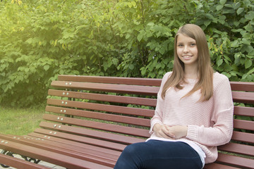 Obraz premium Beautiful teenager girl on the bench
