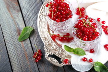 Fresh red currants in glasses on table close up