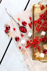 Fresh red currants with sugar on table close up