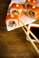 Rolls with sauce and sticks on wooden table close up