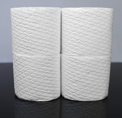 Many white embossed rolls of toilet paper