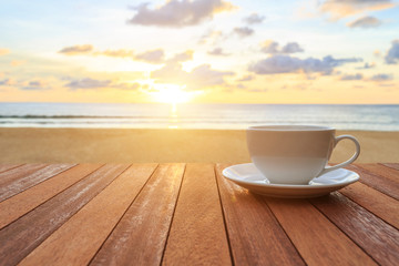 White coffee cup on wood table and view of sunset or sunrise bac