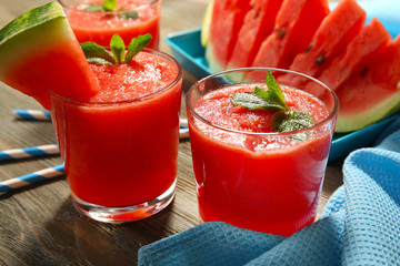 Glasses of watermelon juice on wooden table, closeup