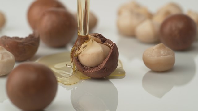Pouring oil on macadamia nuts. Shot with high speed camera, phantom flex 4K.  Slow Motion. 