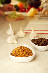 Variety of spices in ceramic containers on the kitchen table